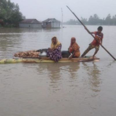 Eine Familie sitzt in einem Boot und sucht nach einem sichereren Unterstand. Bei der Flut in Bangladesch haben viele Menschen ihr Zuhause verloren.