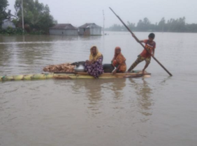Eine Familie sitzt in einem Boot und sucht nach einem sichereren Unterstand. Bei der Flut in Bangladesch haben viele Menschen ihr Zuhause verloren.