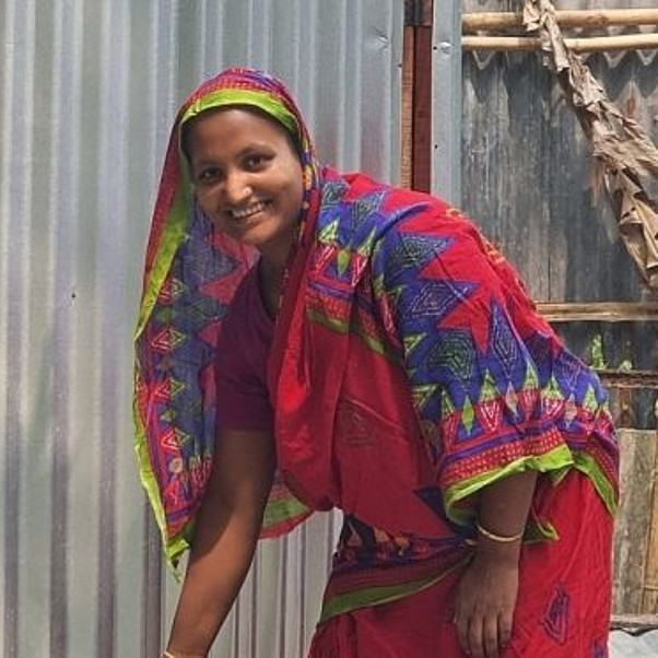 Bangladesch: Frau steht vor der Toilette im garten
