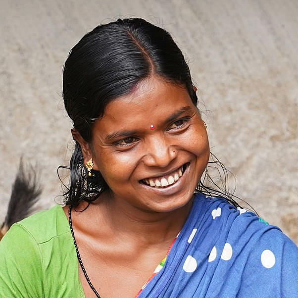 Junge indische Frau in einem grünblauen Sari lacht