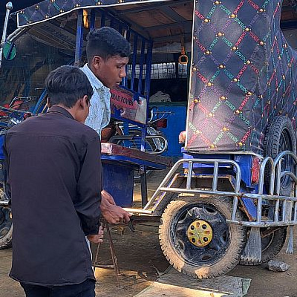 Bangladesch: Junge Männer reparieren eine Rikscha