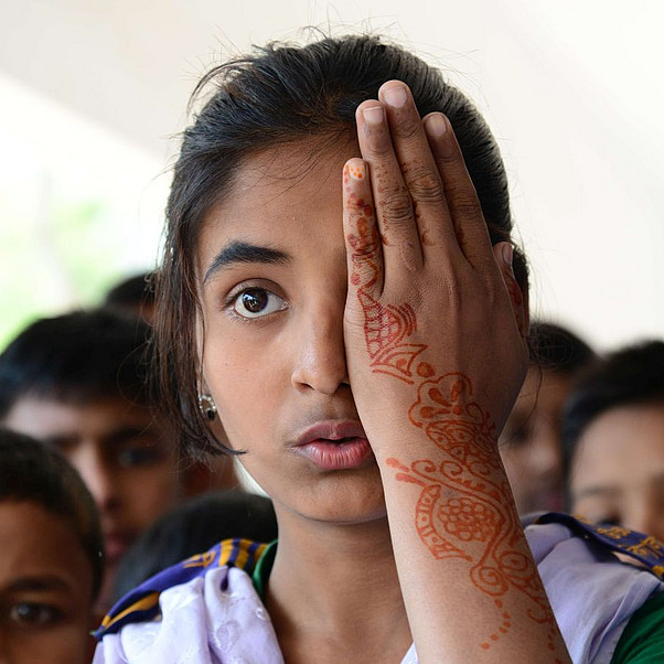 Mädchen in Bangladesch wird am Auge untersucht