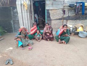 Indien: Frauen mit Kind vor einer Hütte