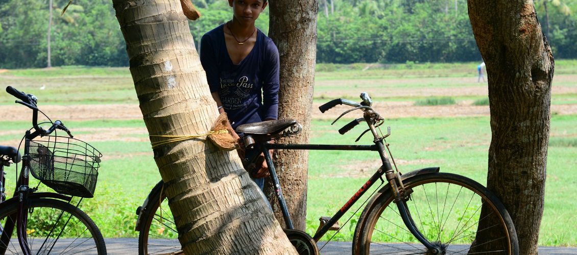 Indischer Junge mit seinem Fahrrad