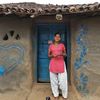 Indien: Eine Frau steht vor ihrem Haus