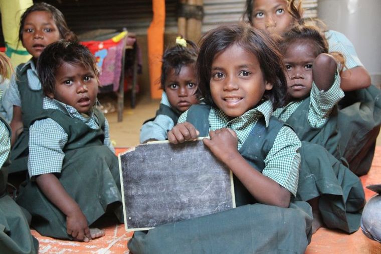 Indien: Kinder sitzen auf dem Boden einer Schule