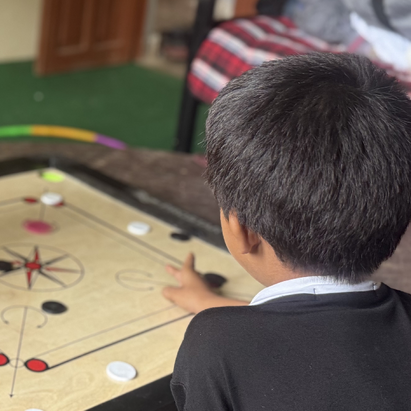 Nach der Flut in Nepal: Ein Kind von hinten fotografiert sitzt an einem Tisch und spielt