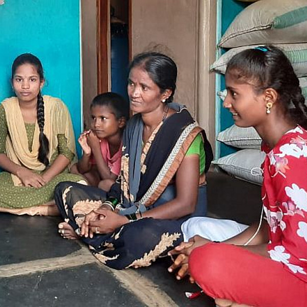 Indische Frauen und Mädchen sitzen auf dem Boden und diskutieren