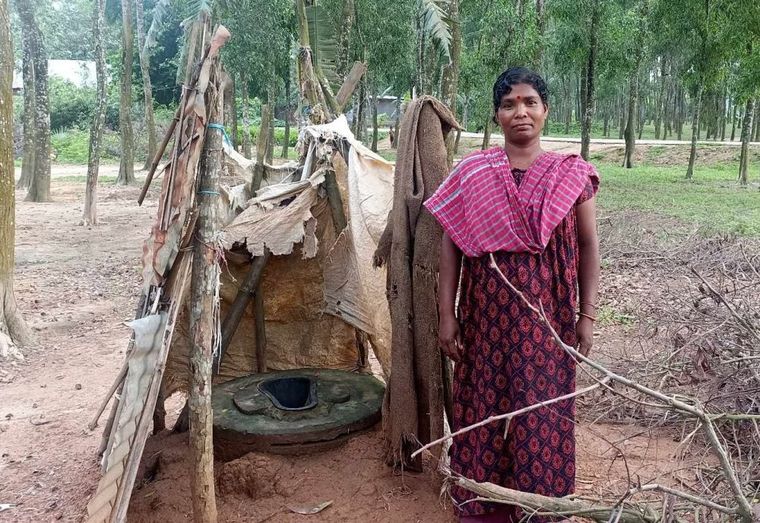 Bangladesch Frau steht vor einer Toilette