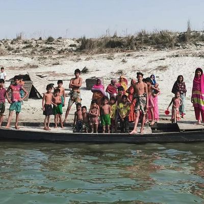 Menschen vor ihrem Boot auf einer Flussinsel in Bangladesch