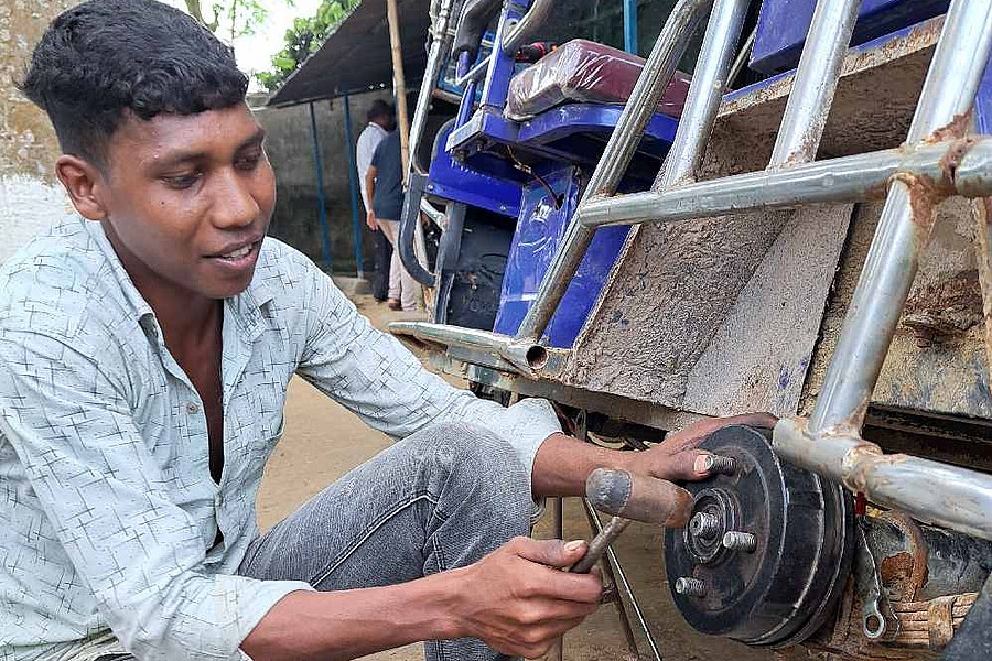 Bangladesch: Ein junger Mann repariert eine Rikscha