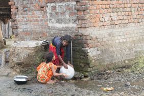 Kinder im Slum holen Wasser