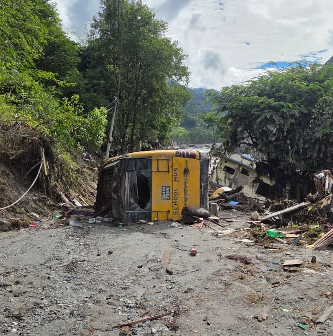 Nach der Sturzflut in Nepal: Ein auf der Seite liegender gelber Bus
