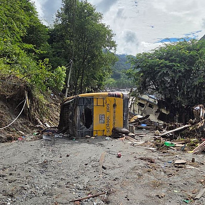 Ein Bus liegt nach der Flut in Nepal im Schlamm