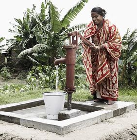 Indien: Ein Frau steht am Brunnen und holt Wasser